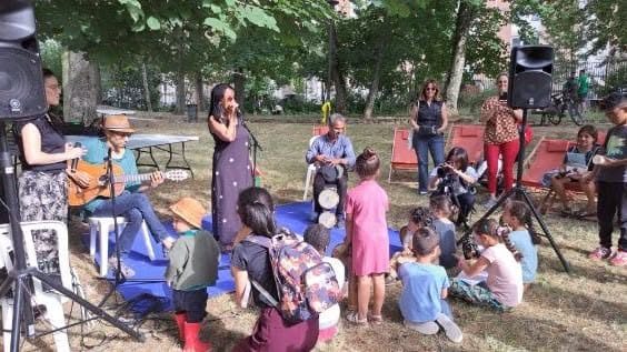 Familles assises dans un parc écoutant les musiciens