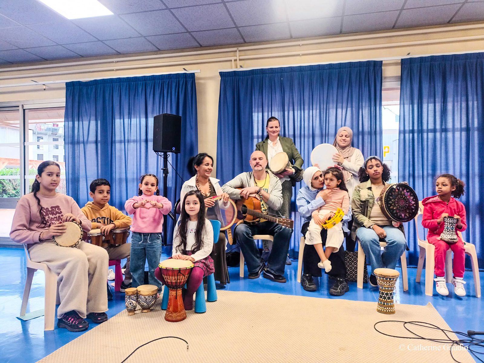 Portrait de groupe d'un atelier de percussions, enfants et adultes ensemble