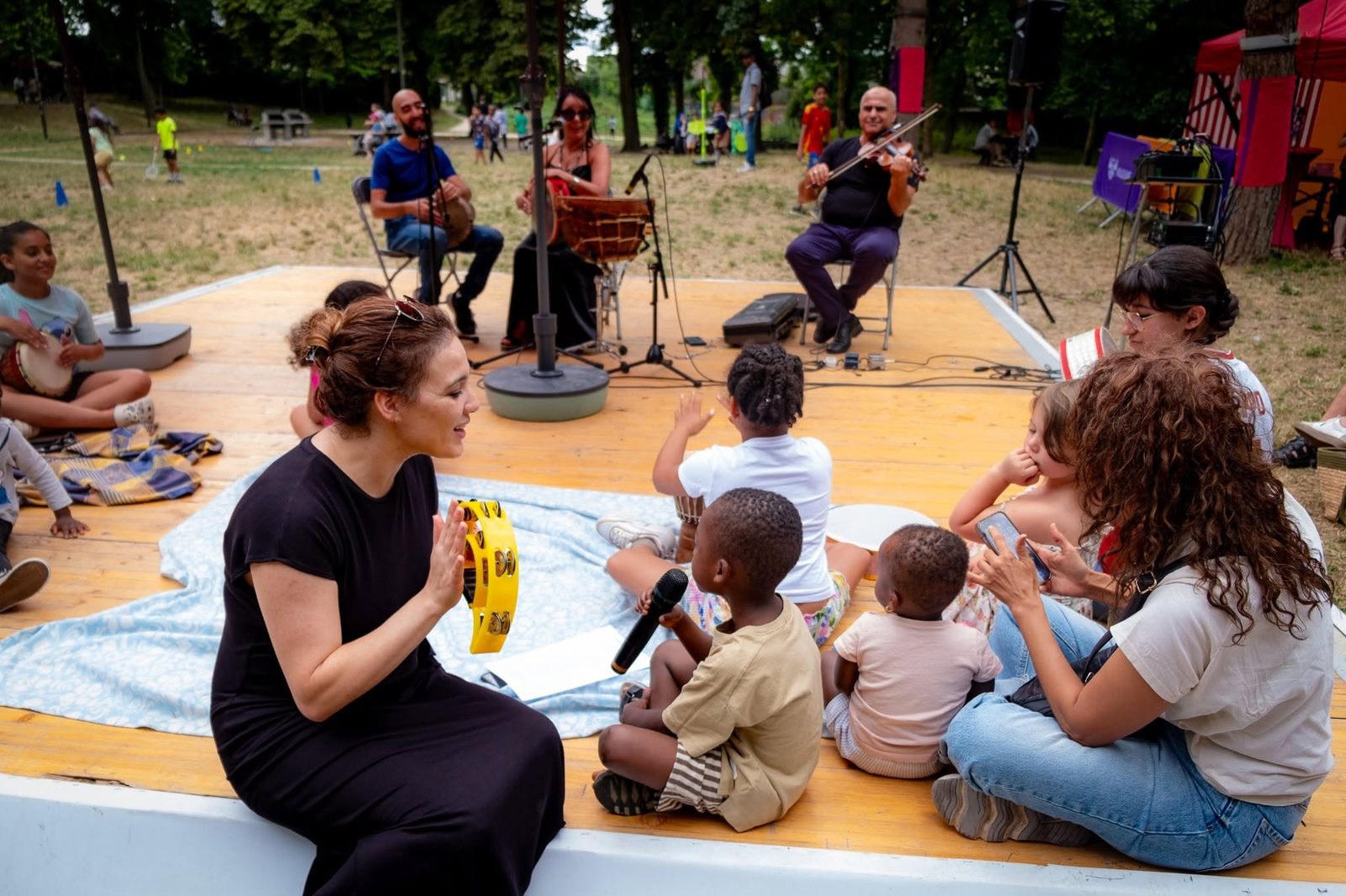 Des enfants chantent au micro avec les musiciens devant le public