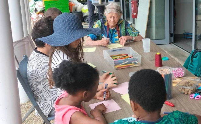 Enfants et aînés autour d'une table pendant un atelier scientifique intergénérationnel