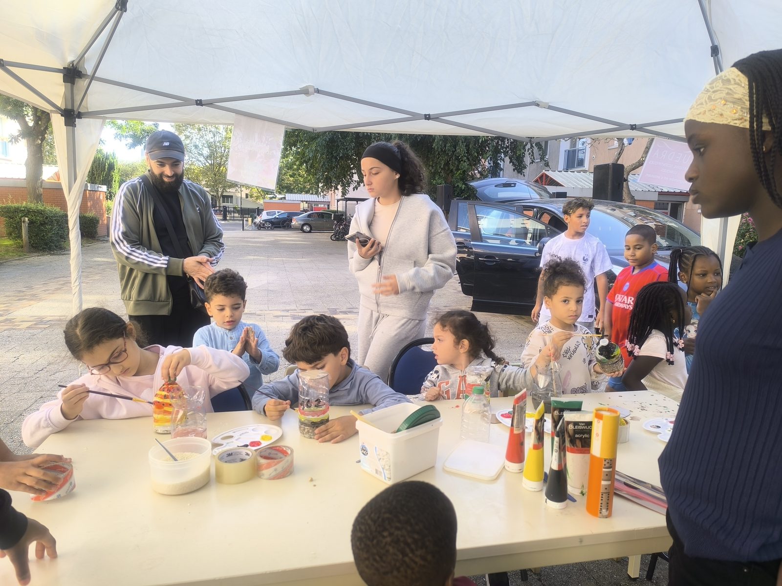 Enfants peignent sous une tente blanche
